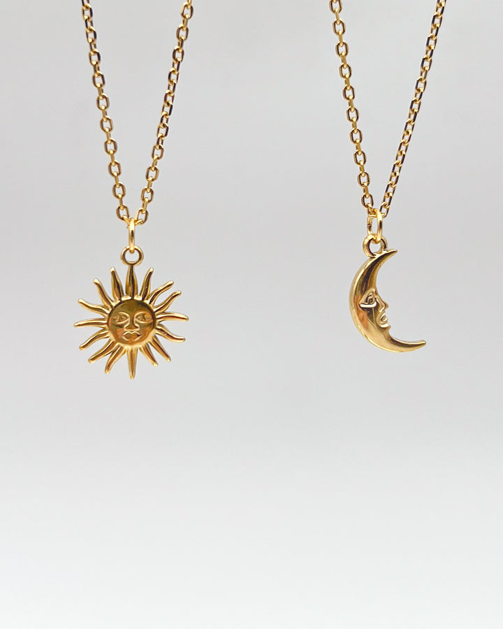 Pendentifs soleil et lune présentés sur un fond neutre