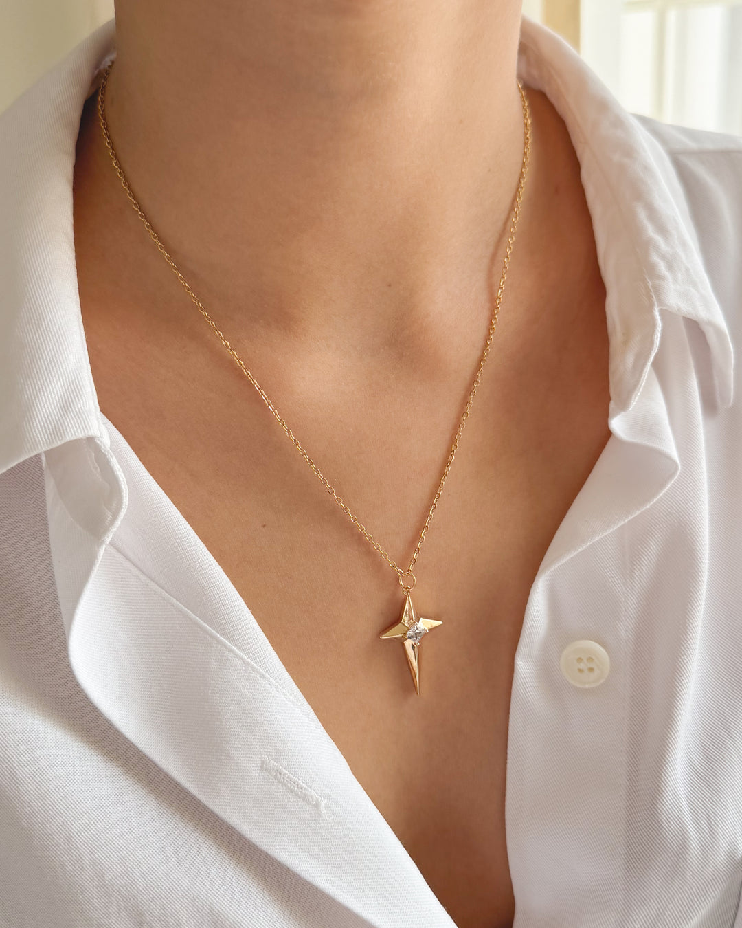 Collier étoile du nord porté avec une chemise blanche pour un look élégant.