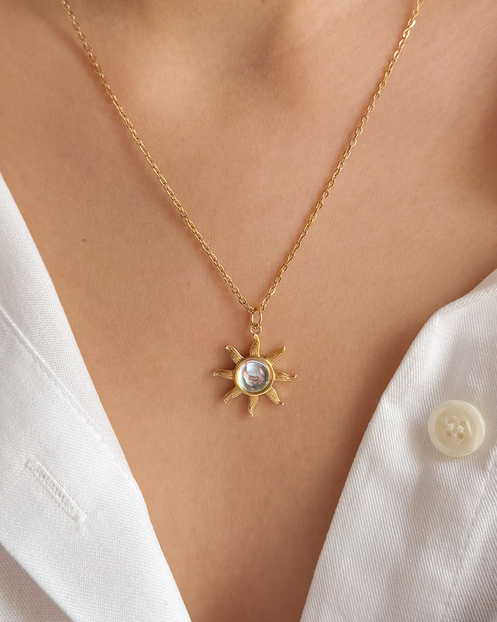 Collier pendentif soleil porté sur un cou de femme
