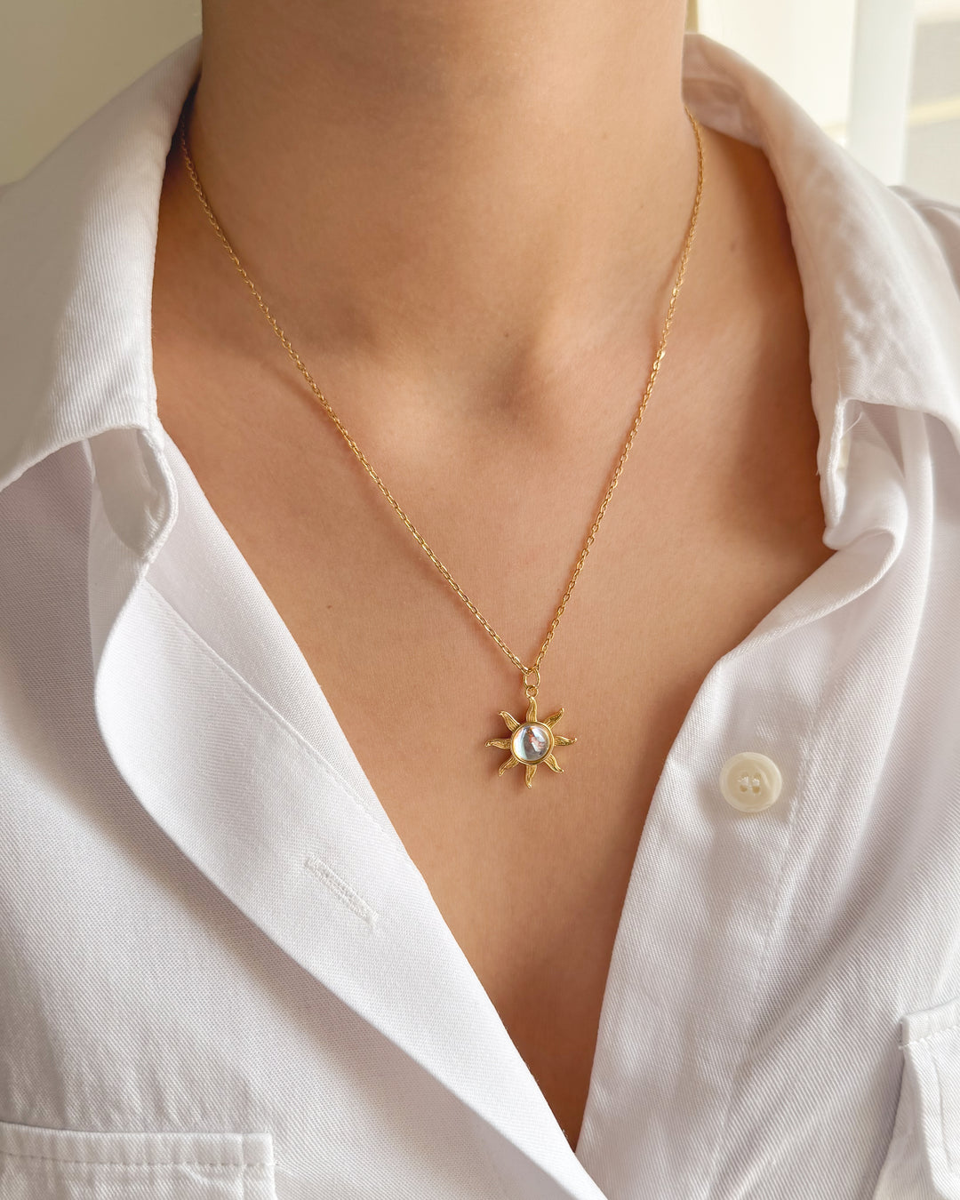 Collier pendentif soleil associé à une chemise élégante pour un look rayonnant
