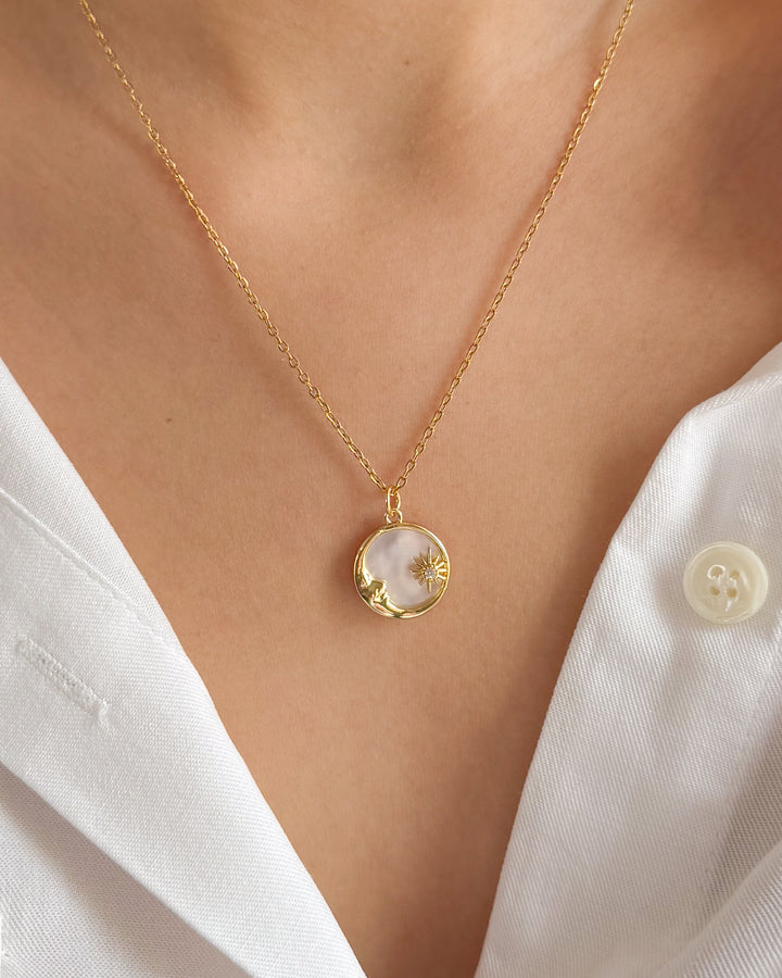 Duo de bijoux lune et soleil assortis à une chemise blanche pour un style harmonieux et raffiné
