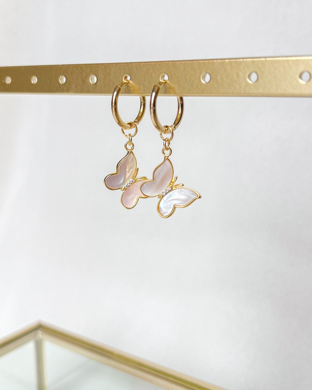 Les boucles d'oreilles nacres vues de profil sur fond neutre.