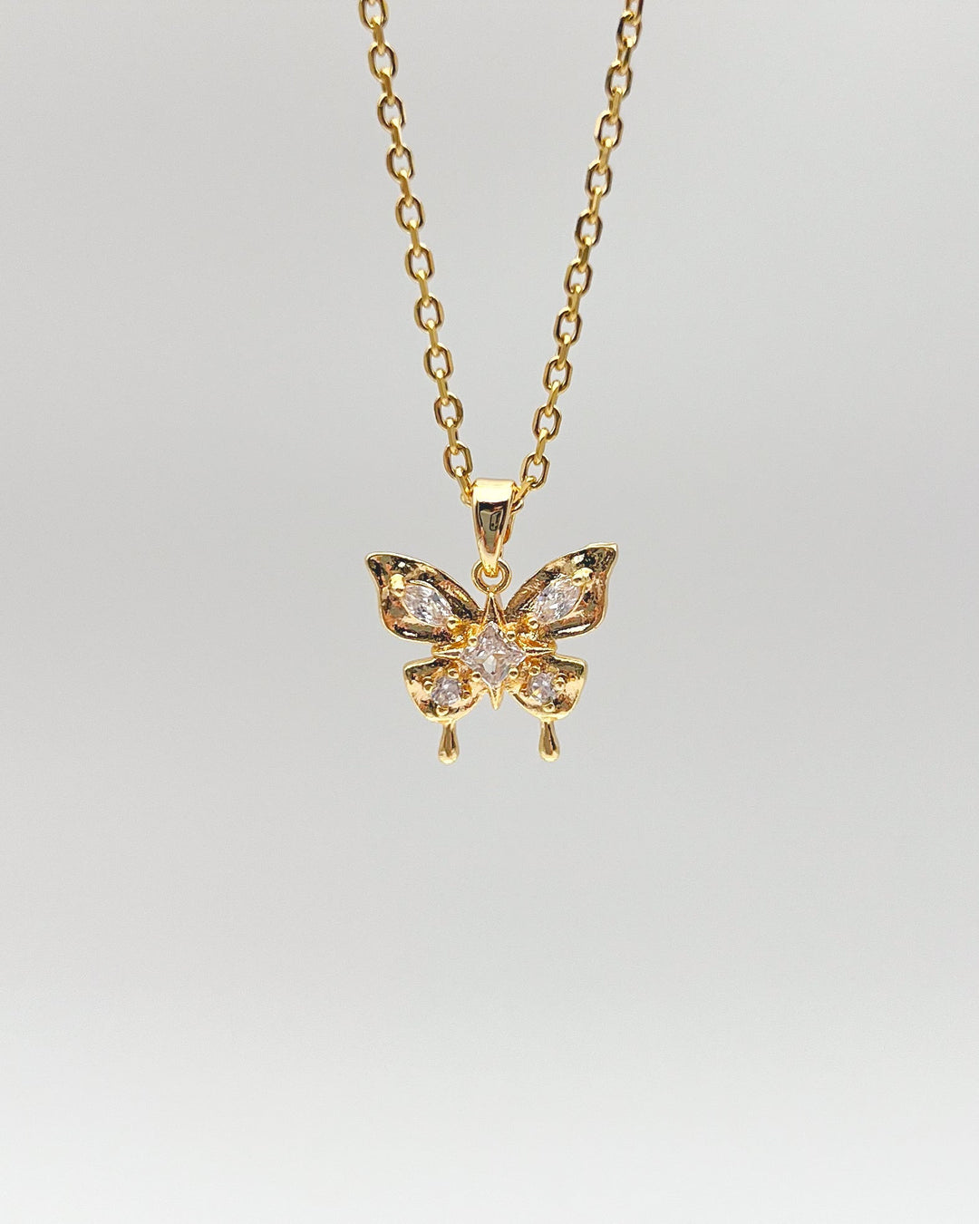 Collier papillon sur fond neutre.