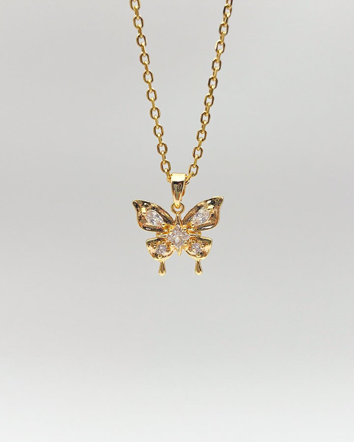 Collier papillon sur fond neutre.