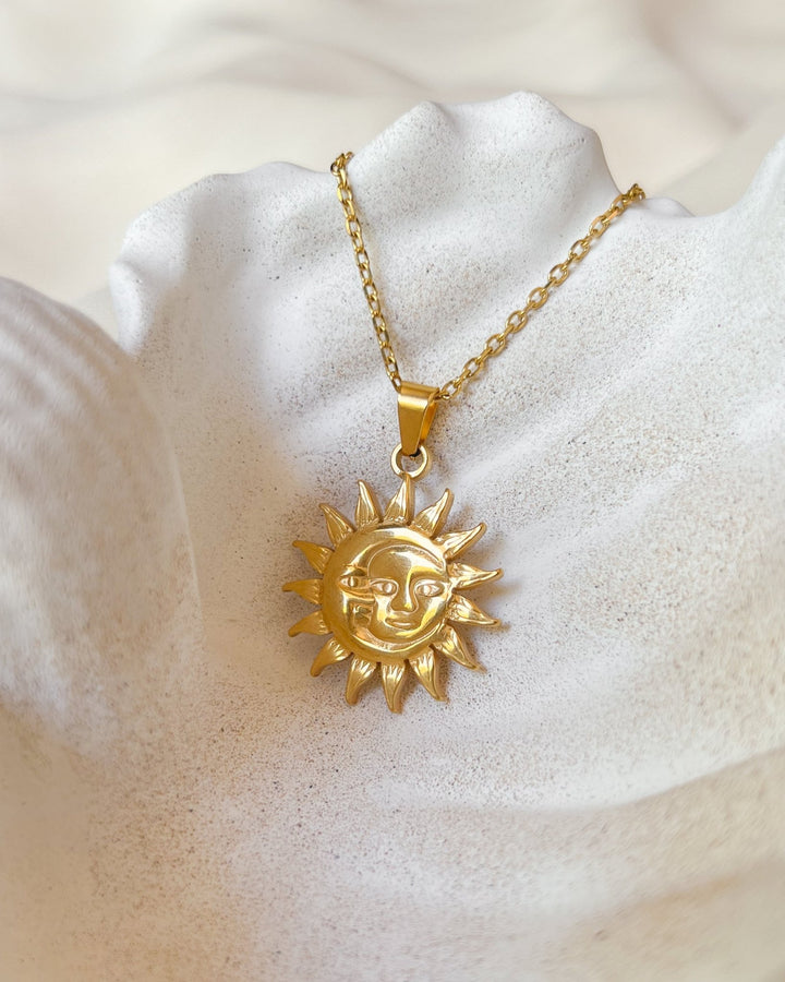 Collier solaire présenté sur une assiette en forme de coquillage.