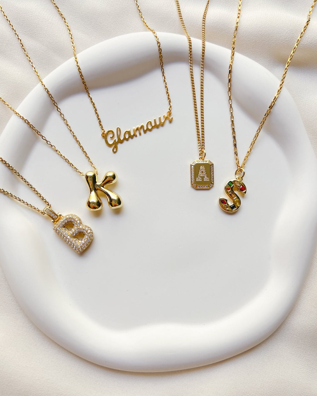 Bijoux faits main : créations personnalisées  avec initiales, pierres de naissance et charms pour un style sur mesure.