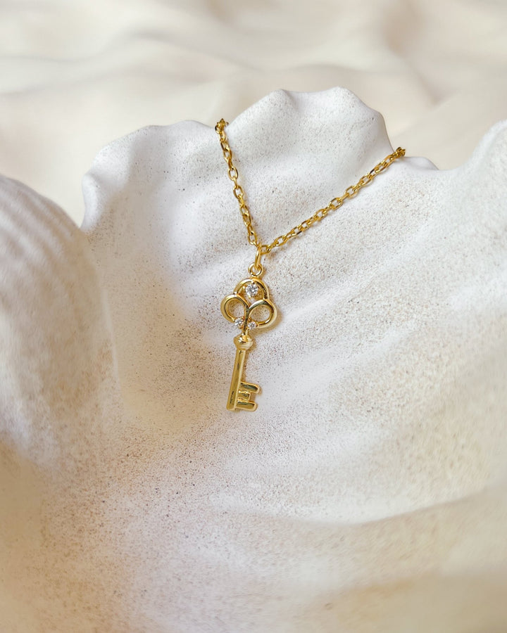 Collier Key posé sur une assiette en forme de coquillage.