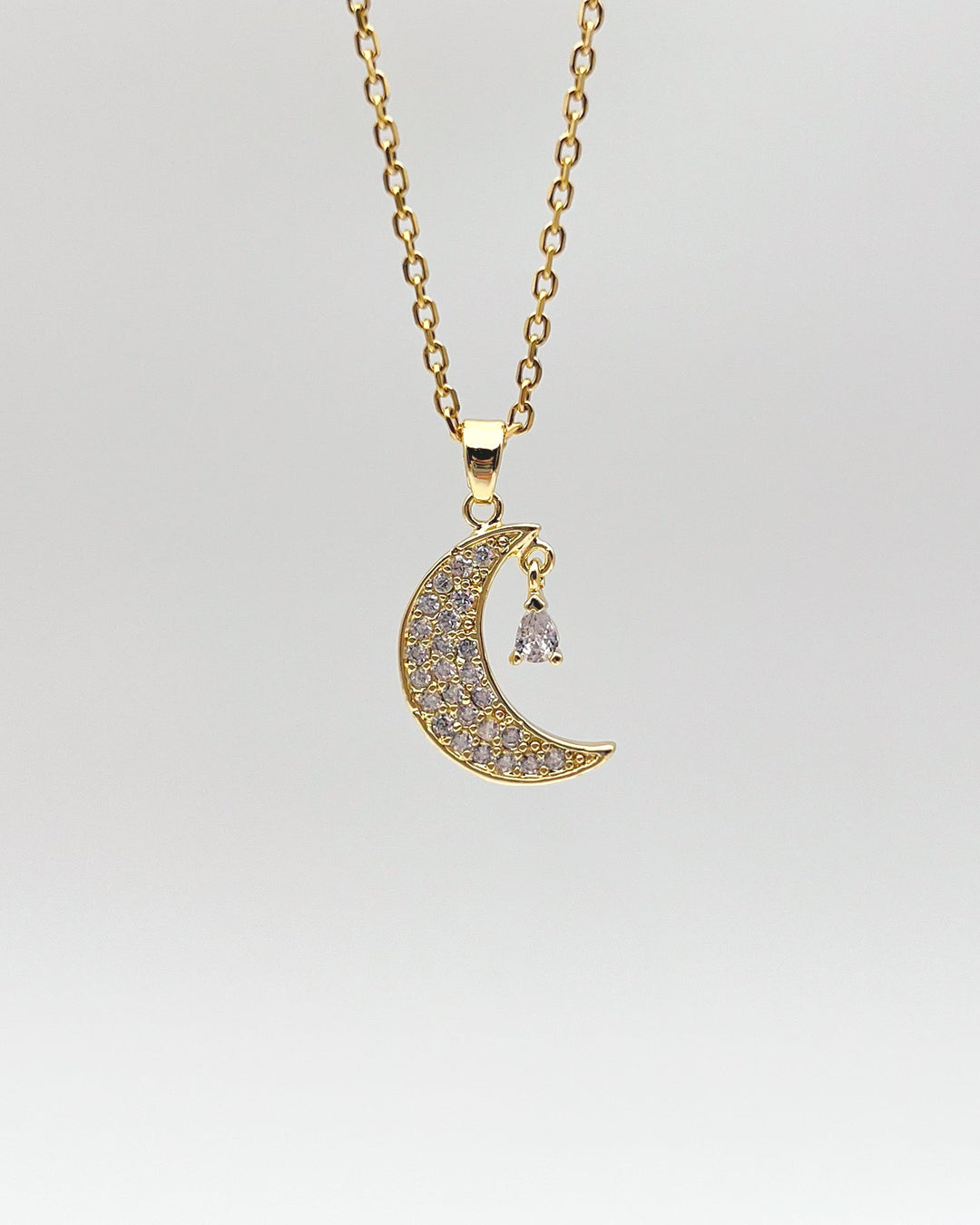 Collier croissant de lune sur fond neutre.